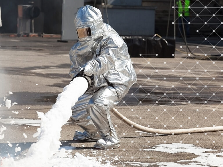 Firemen spray firefighting foam