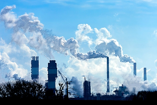 Factory with multiple smoke stacks against blue sky. Meteorological monitoring, Air Testing