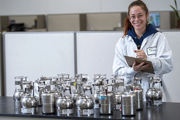 Pace Scientist holding clipboard documenting air canisters, ambient air