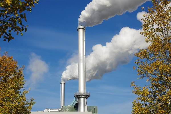 2 incinerator smoke stacks against blue sky. Pace Stack emission testing for industry