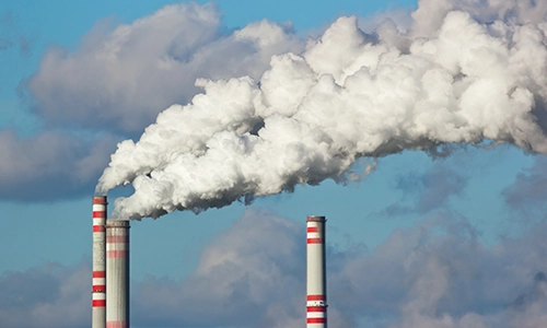 three red and white smoke stacks against a blue sky. Pace stack emissions, stack emissions testing