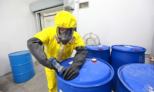 person in hazmat suit sealing blue barrel of hazardous waste. Explosives testing, Testing explosives, Explosives analysis, Detection of explosives
