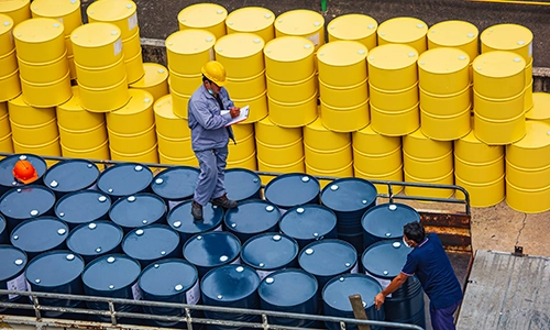 Worker inspecting barrels of chemical ready for transport. Blue and Yellow barrels. What are Volatile Organic Compounds? Volatile Organic Compounds (VOC), Sources of volatile organic compounds, Volatile Organic Compounds testing