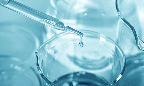 dropper dropping liquid into beaker in laboratory. Semi-Volatile Organic Compounds, SVOCs