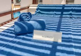 Blue pool lounger with blue towels and Reserved sign at spa pool. Paceº Services for the Hospitality Industry.